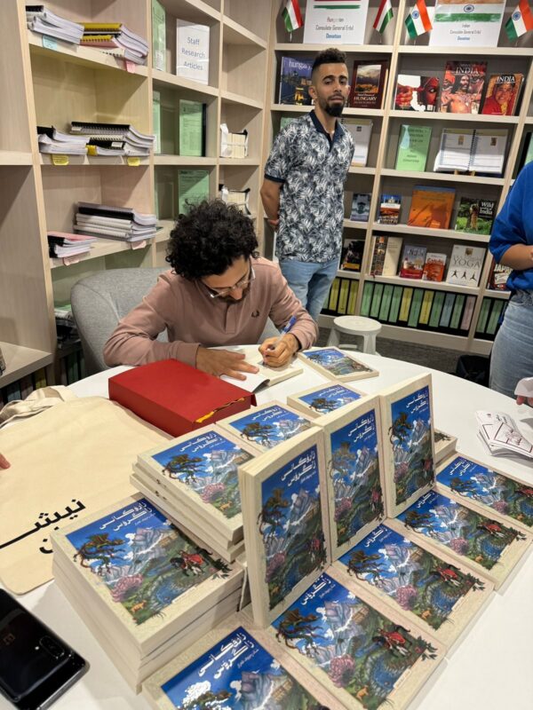 Shad Raouf Qazaz signing copies of the Kurdish edition of Children of the Zagros